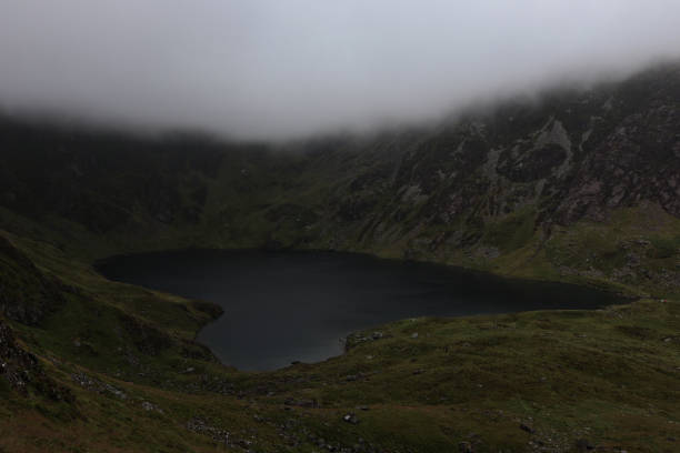 Mountain Lake, Cadar Idris, Snowdonia Hiking up Cadar Idris on an overcast day and looking down on to the lake half way up the mountain walk cadar stock pictures, royalty-free photos & images