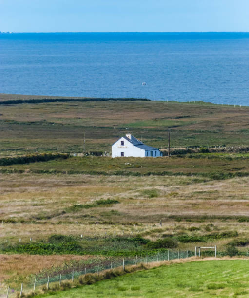 istock white old house in fields by the ocean in ireland 1364987369