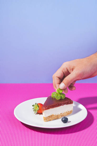 istock Hand decorating homemade cake on pink and blue background with copyspace. Vertical format. Homemade bakery concept. 1364988730