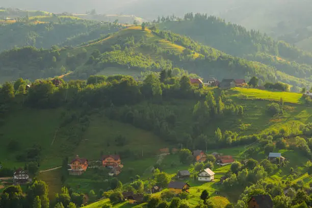 Photo of Houses and farms on the hillside in Magura village in Romania