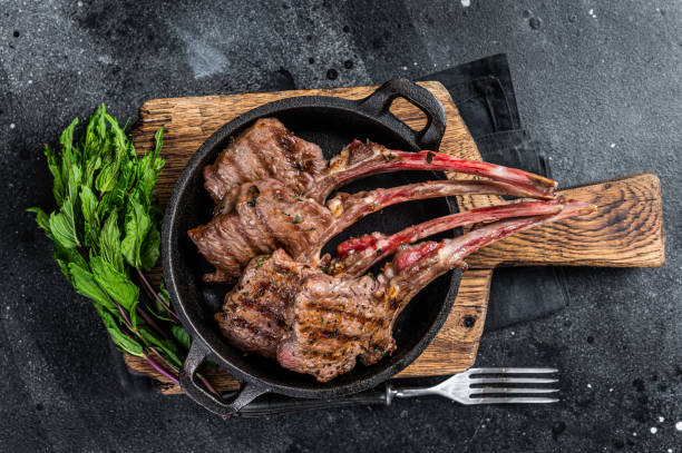 istock BBq Grilled lamb mutton chops steaks in a pan. Black background. Top view 1364989189