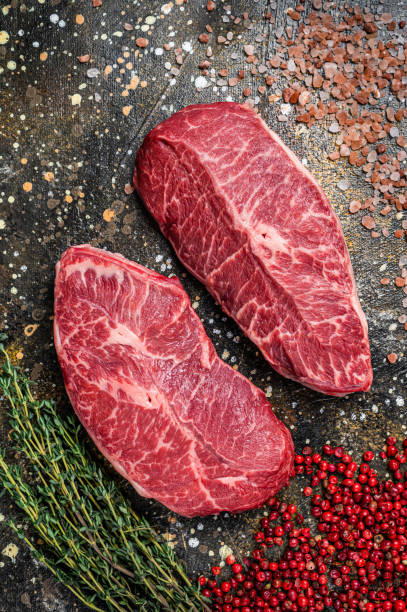 Raw Shoulder Top Blade cuts, beef meat steaks. Brown background. Top View Raw Shoulder Top Blade cuts, beef meat steaks. Brown background. Top View. boneless chuck steak stock pictures, royalty-free photos & images