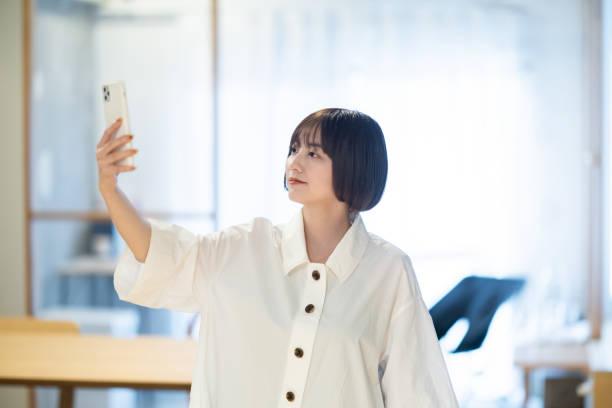 istock A woman holding a smartphone indoors 1364990244