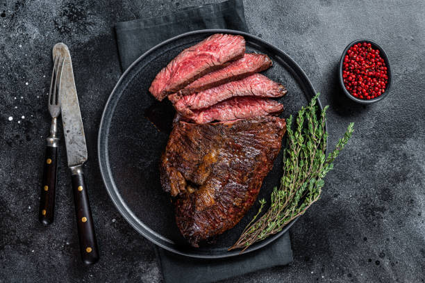 cintre grillé ou steak de viande de bœuf onglet sur une assiette avec du thym. fond noir. vue de dessus - roast beef photos et images de collection