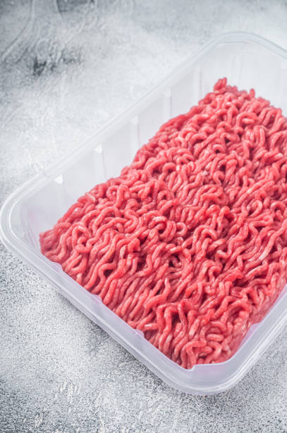 istock Fresh Raw mince beef and pork meat in vacuum packaging. White background. Top view 1364991056