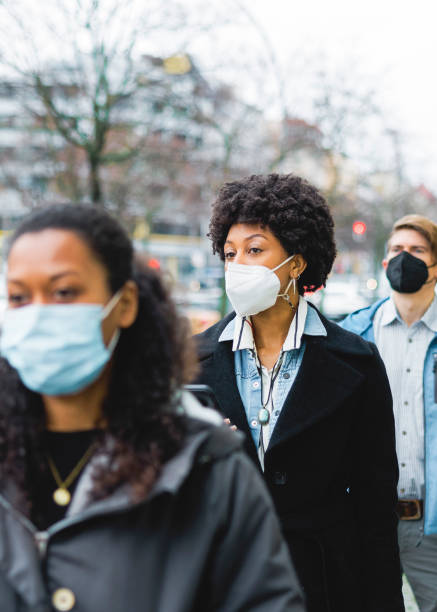 istock People standing at temperature checkpoint line outside office 1364991865