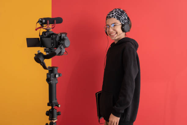 istock Smiling young vlogger using headphones in front of camera talking and recording podcast 1364995503
