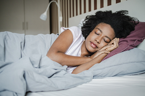 African American woman is sleeping in bed in the morning