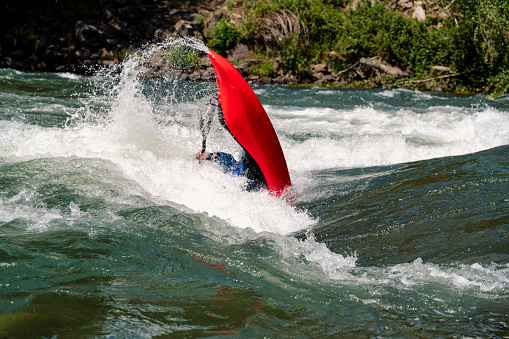 Kayaking Freestile competitor man completing 360 degree maneuver\