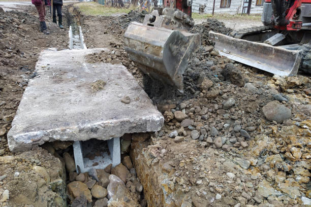 istock The excavator puts concrete slabs for moving through the gutter, construction work with an excavator. 1364997549