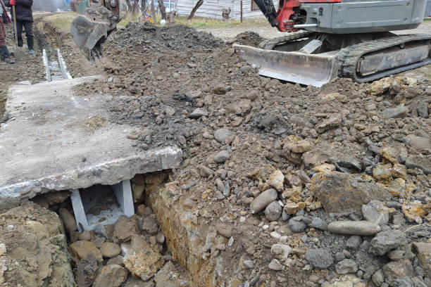 istock The excavator puts concrete slabs for moving through the gutter, construction work with an excavator. 1364998827