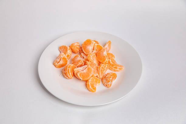 istock Tangerine slices on a white plate. 1364999046