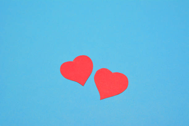 istock two red paper hearts on blue background, place for text 1365000237