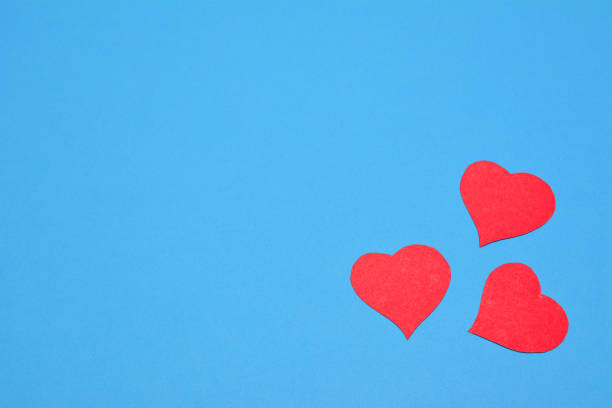 istock scarlet paper hearts on blue background, place for text 1365000268