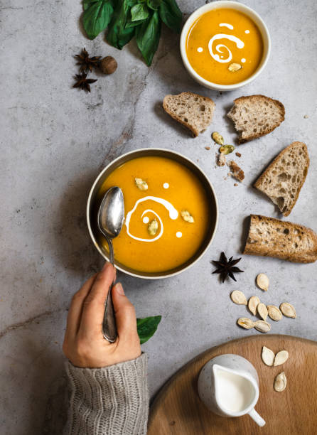istock Pumpkin soup with bread, seeds and cream 1365002312