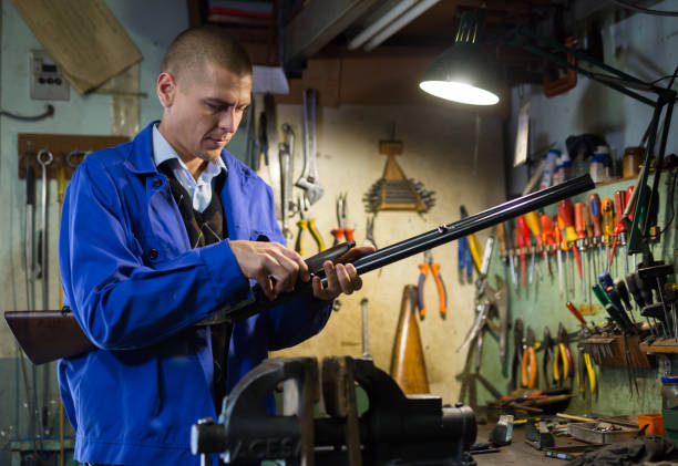 istock Gunsmith examines and checks double-barreled hunting rifle in weapons workshop 1365002913