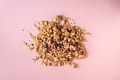 granola with nuts and chocolate on a beige background, flat lay