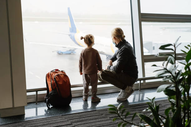 istock Father and child looking though lounge window at airport 1365003593