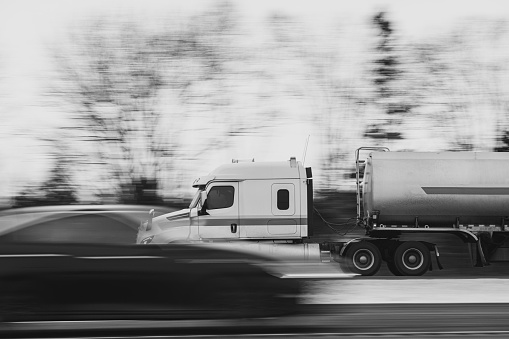 Semi truck on a multi lane highway in Winter. Slow shutter panning shot with lots of motion blur.
