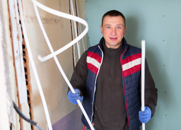 istock Repair man with cable duct standing in room and looking at camera 1365004716