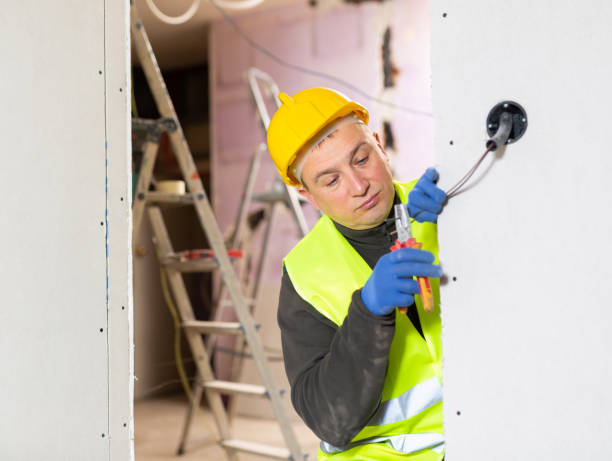 istock Electrician mounting electrical wiring inside building in process of construction 1365004721