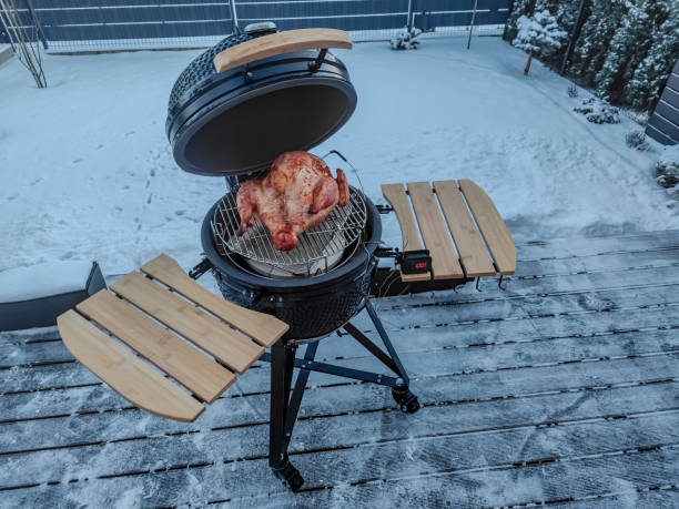 istock Large kamado type barbeque grill with turkey being grilled in winter 1365006266