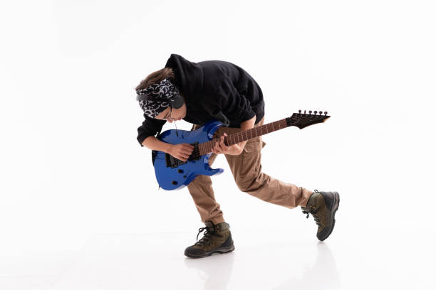 istock Young Guitar Player dancing and plaing guitar on White Background 1365007035