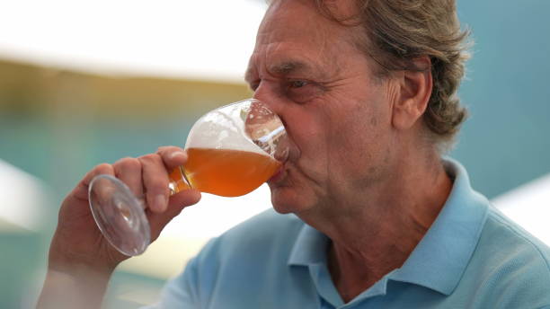 istock Happy senior man drinking beer with friends in conversation 1365008657