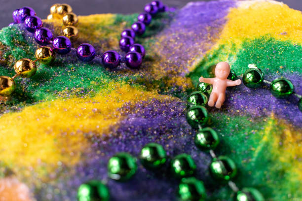 King cake with Mardi Gras beads and baby stock photo