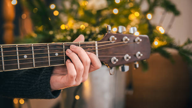 istock Close-up, female hands playing the guitar on a blurred background. 1365010626