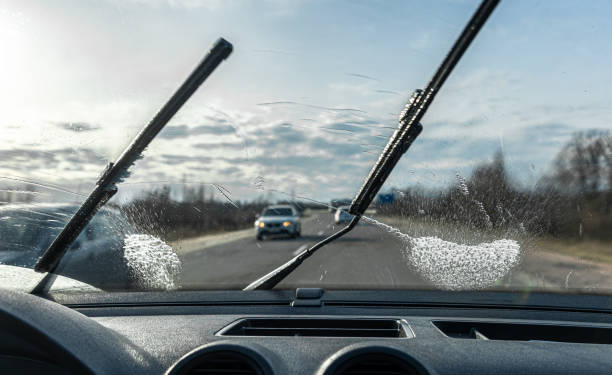 Car wipers clean windshields when driving in sunny weather. Car wipers clean windshields when driving in sunny weather, inside view. windshield wiper photos stock pictures, royalty-free photos & images