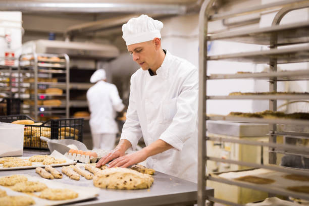 istock male baker in white uniform rolling out dough in kitchen 1365013134