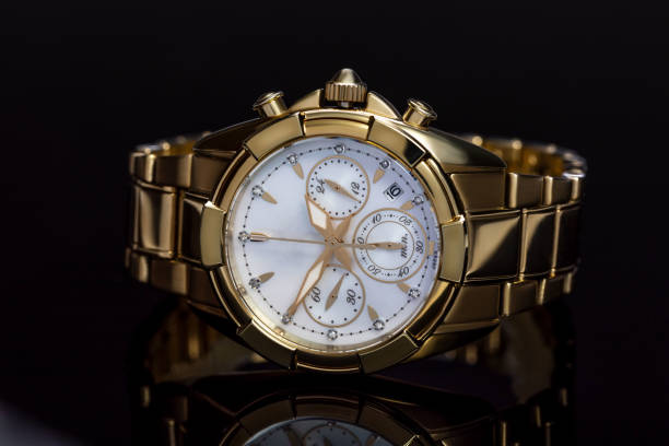 orologio da donna dorato con bracciale in metallo, cronometro, pietre preziose, diamanti su sfondo nero con riflessi. il concetto di un regalo costoso per le donne, il lusso. primo piano, macro - gold watch foto e immagini stock