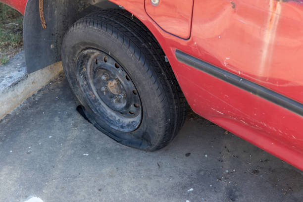 istock Destroyed blown out tire with exploded, shredded and damaged tire on a modern automobile. damaged truck rubber after tire explosion at high speed. Damaged flat tires: old car. 1365016650