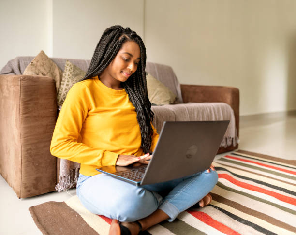 istock Young woman using laptop on her living room floor 1365016725