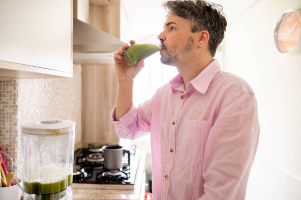 istock Man drinking a freshly made smoothie in his kitchen 1365019958