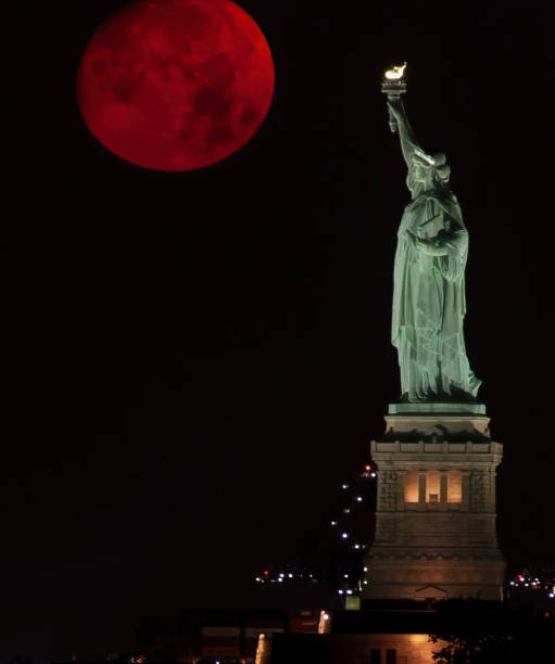 istock Statue of Liberty with Red Full Moon 1365019971