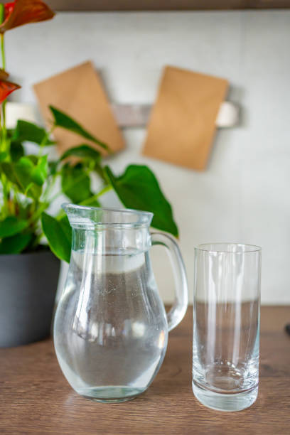 istock Jug with clear cold water on kitchen table in the home 1365021175