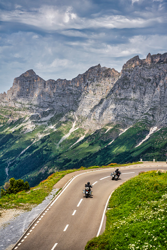 two motorcyclists touring the mountains of the Swiss Alps in Switzerland\