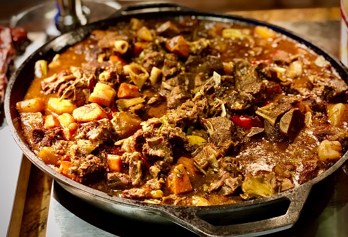 Braised Island goat meat prepared into a savory stew featuring locally grown peppers and yams