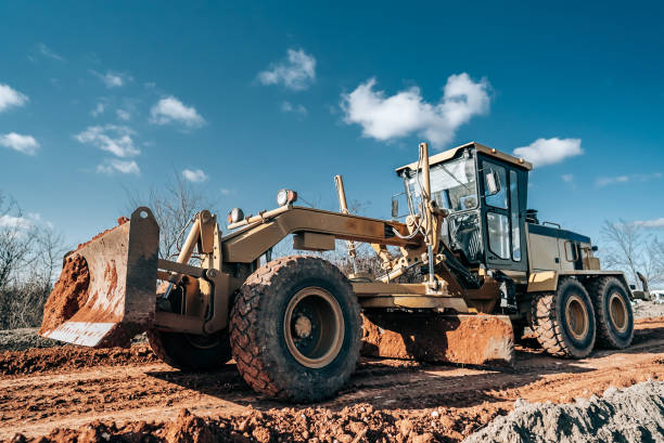 istock Road grader smoothing gravel surface for new road. Scraper leveling ground, working at construction. Earthmoving, excavations, digging on soils. 1365023665