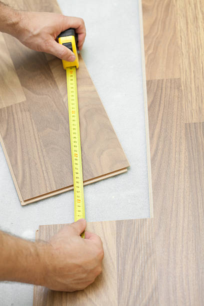 istock Carpenter measuring wooden floor plank 136502592