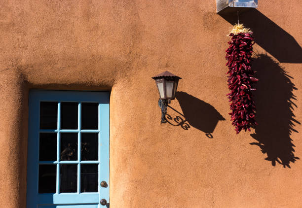 santa fe, nm: chili ristra, puerta turquesa, pared de adobe iluminada por el sol - ristra fotografías e imágenes de stock