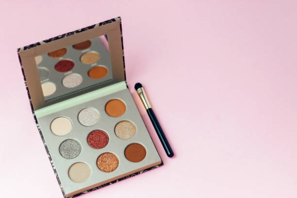 istock Multi-colored pastel brown red eye shadow on a pink background with brushes 1365030362