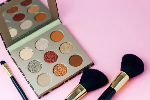 istock Multi-colored pastel brown red eye shadow on a pink background with brushes 1365030370