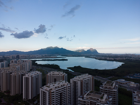 Aerial view at sunset. In the background, the hills of Rio de Janeiro, Brazil and the Jacarépagua lagoon. Sunny Day and some clouds. Drone take