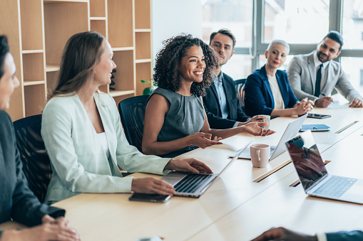 Multiethnic  group of businesspeople sitting together and having a meeting in the office.