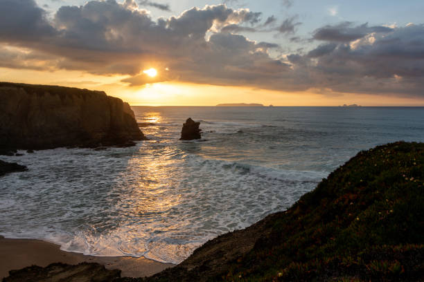 istock Sunset landscape on the ocean with sheer cliffs and foamy waves 1365032739