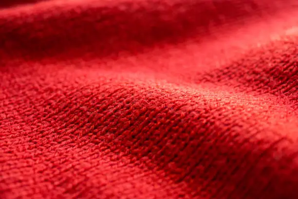 Photo of closeup red knitted woolen fabric texture background