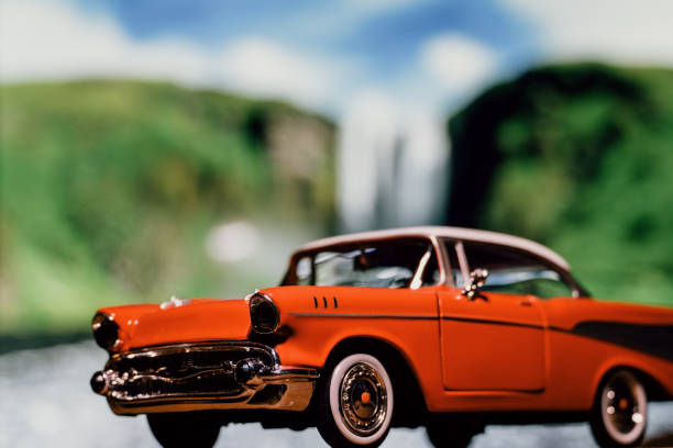 Retro car toy model in front of the waterfall